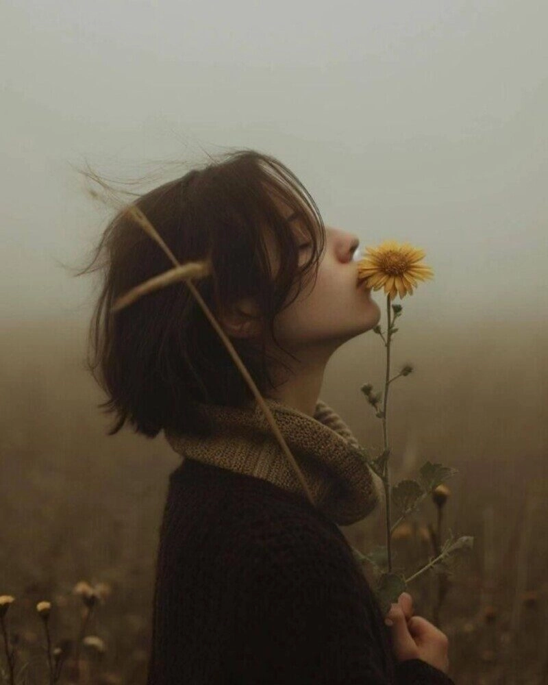 ảnh cô gái cầm hoa che mặt buồn