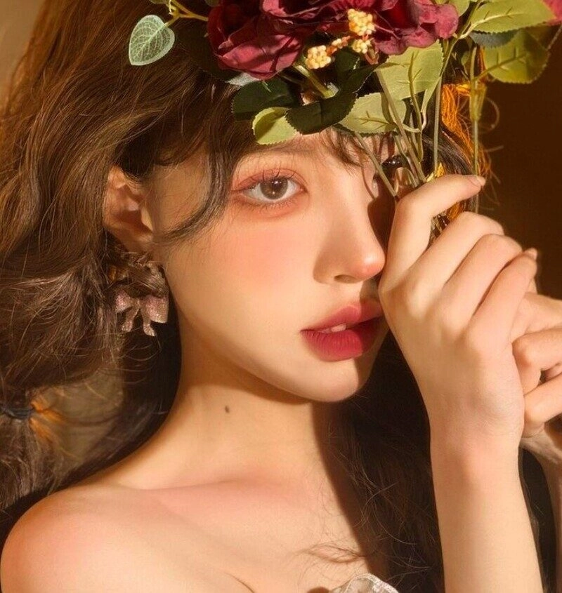 ảnh cô gái cầm hoa che mặt buồn