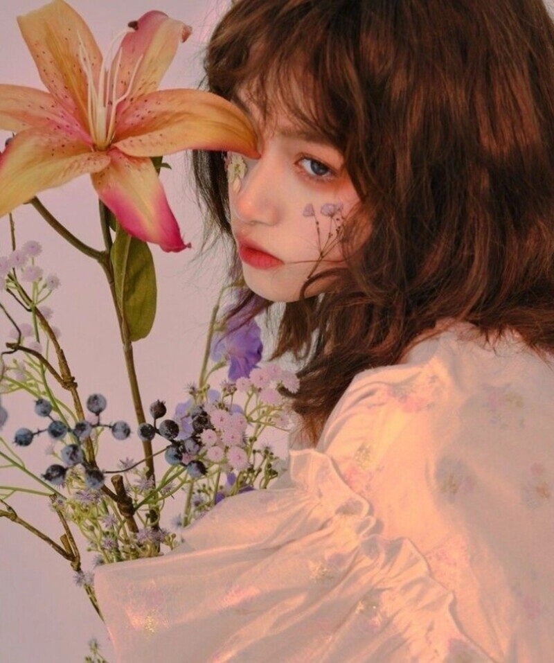 ảnh cô gái cầm hoa che mặt buồn