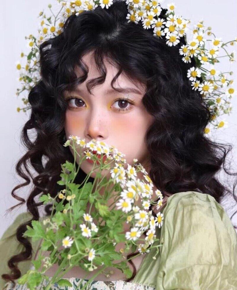 ảnh cô gái cầm hoa che mặt buồn