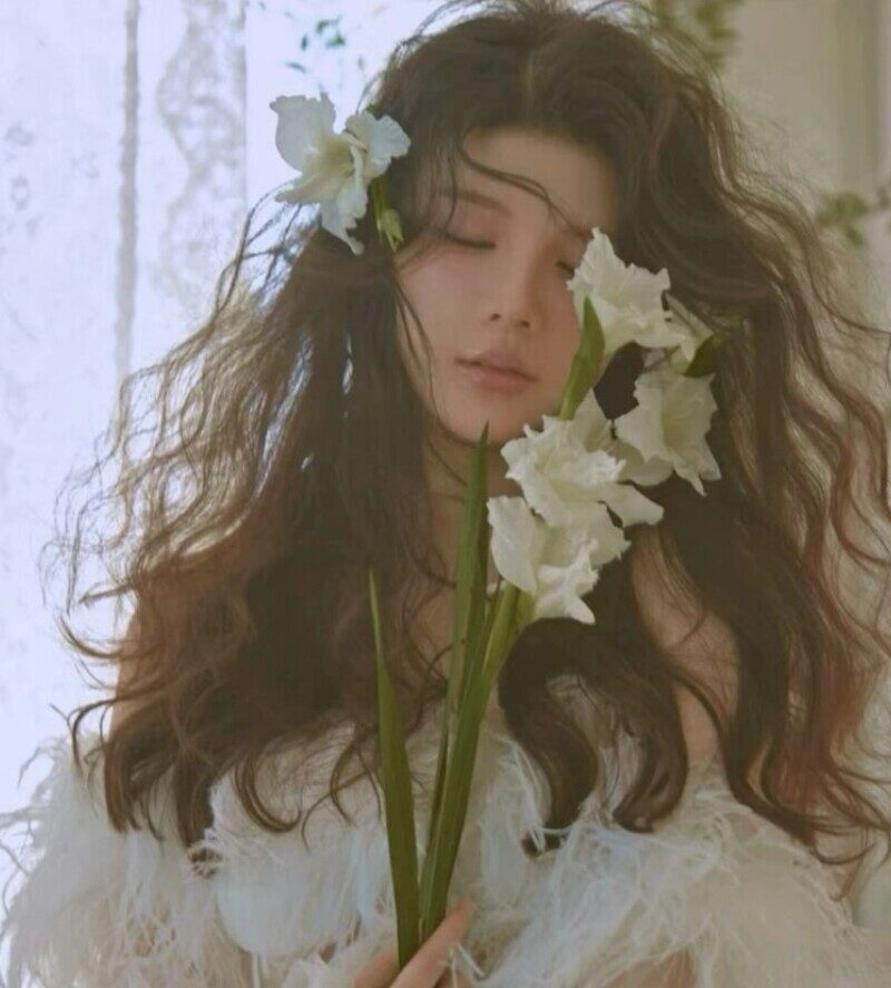 ảnh cô gái cầm hoa che mặt buồn