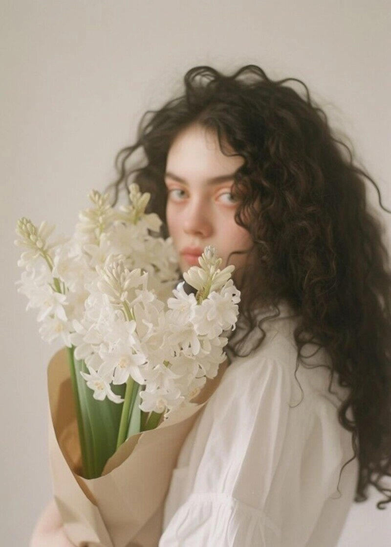 ảnh cô gái cầm hoa che mặt buồn