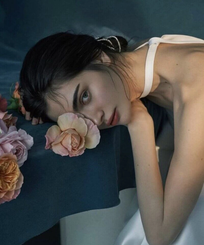 ảnh cô gái cầm hoa che mặt buồn