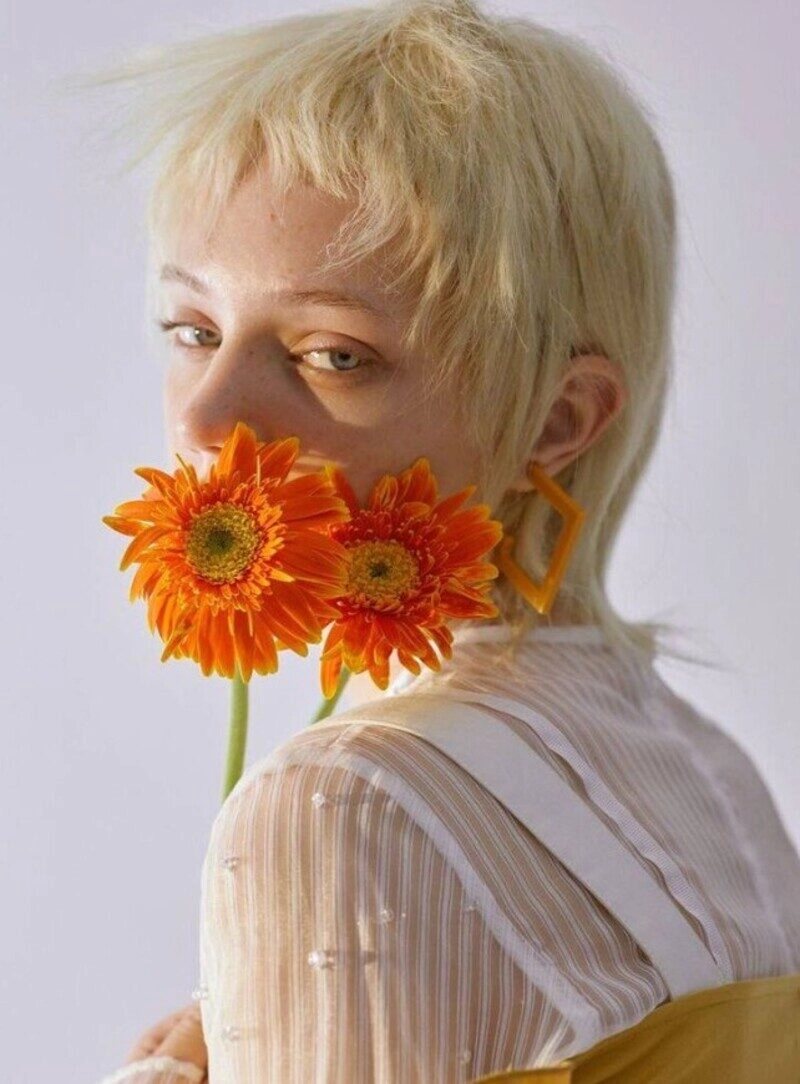 ảnh cô gái cầm hoa che mặt buồn