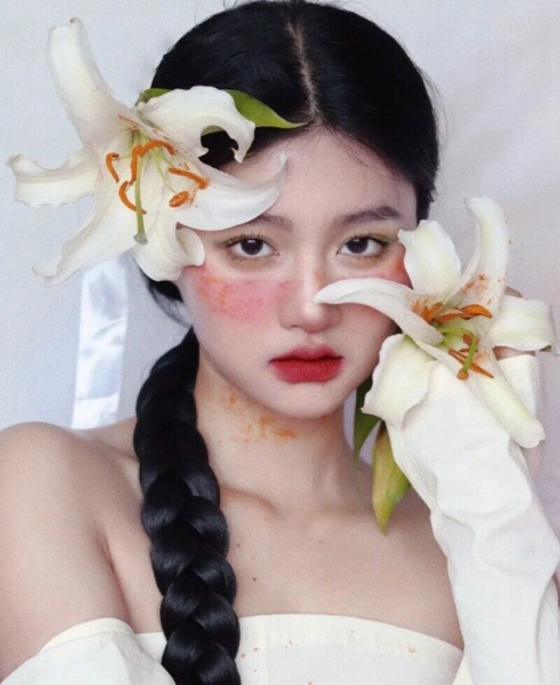 ảnh cô gái cầm hoa che mặt buồn