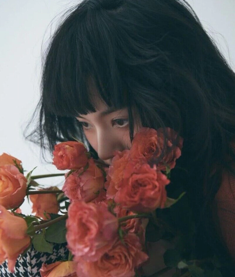 ảnh cô gái cầm hoa che mặt buồn