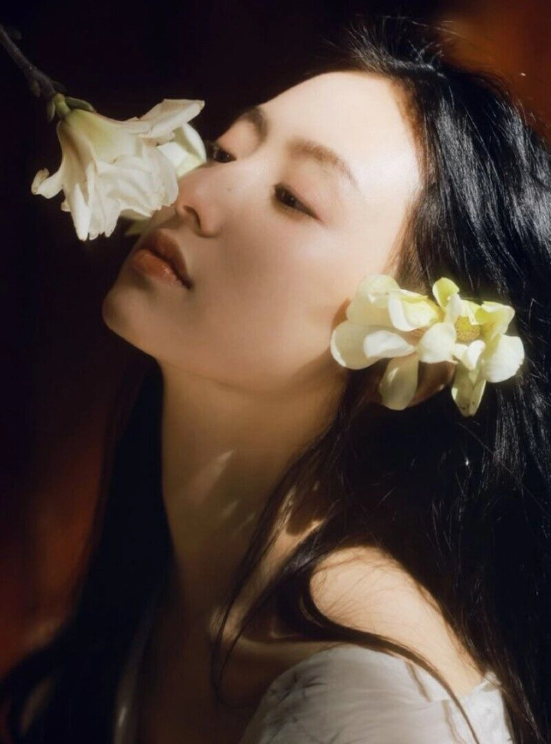 ảnh cô gái cầm hoa che mặt buồn
