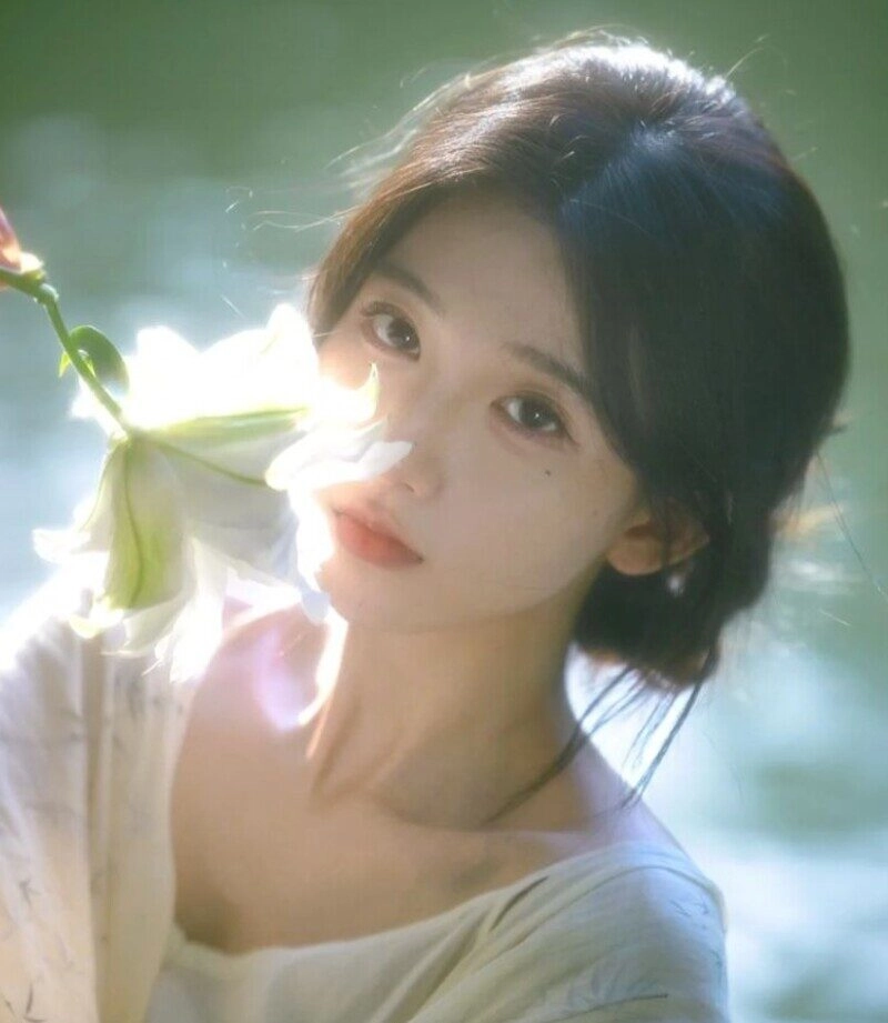 ảnh cô gái cầm hoa che mặt buồn