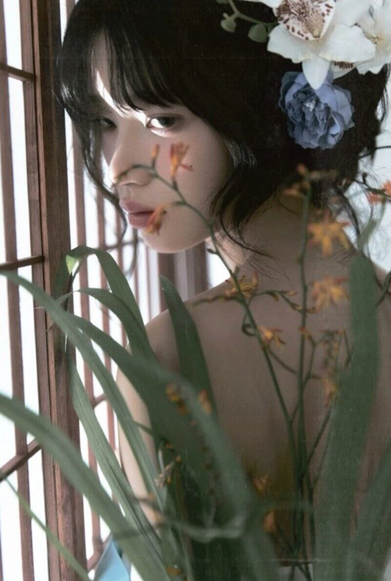 ảnh cô gái cầm hoa che mặt buồn