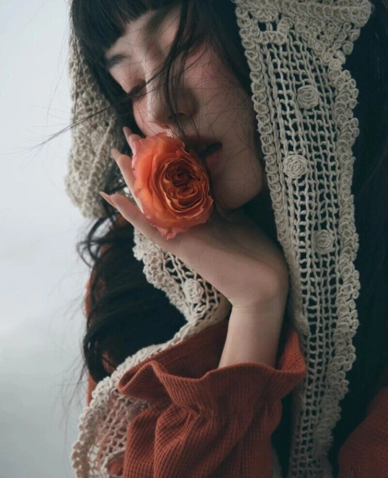 ảnh cô gái cầm hoa che mặt buồn