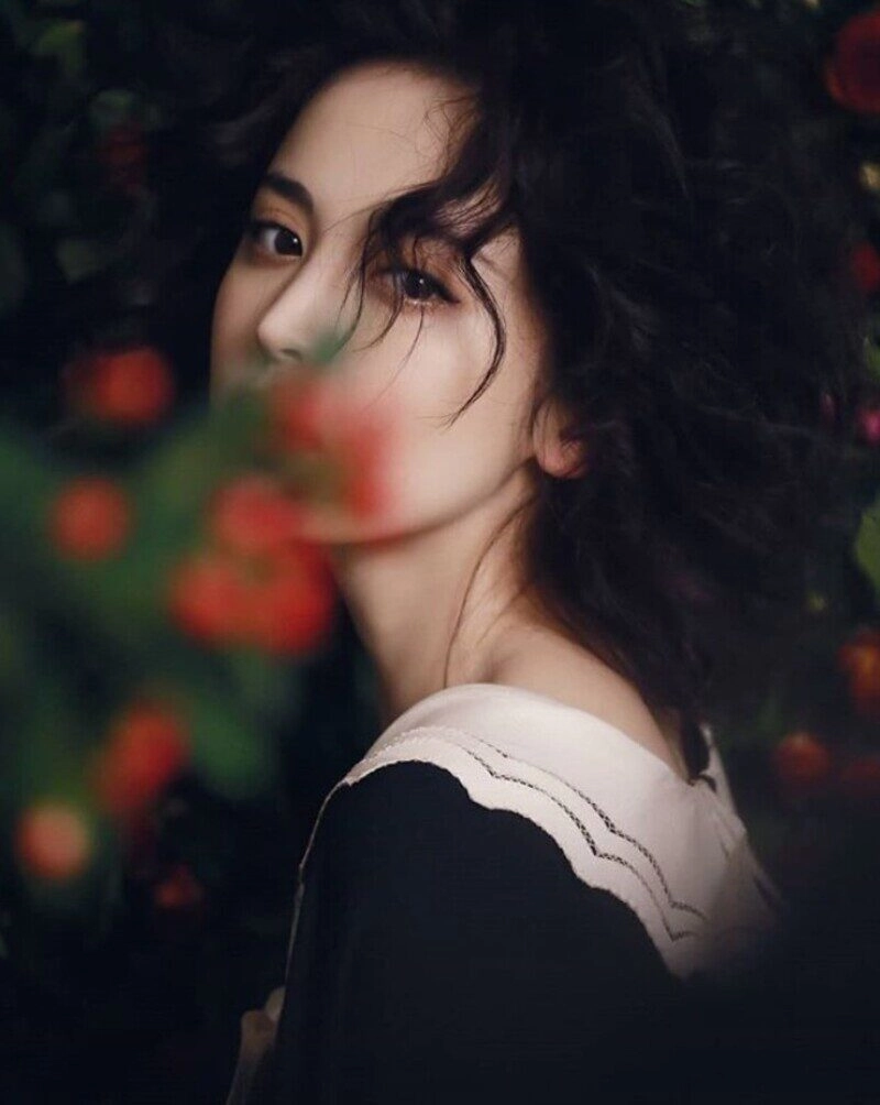 ảnh cô gái cầm hoa che mặt buồn