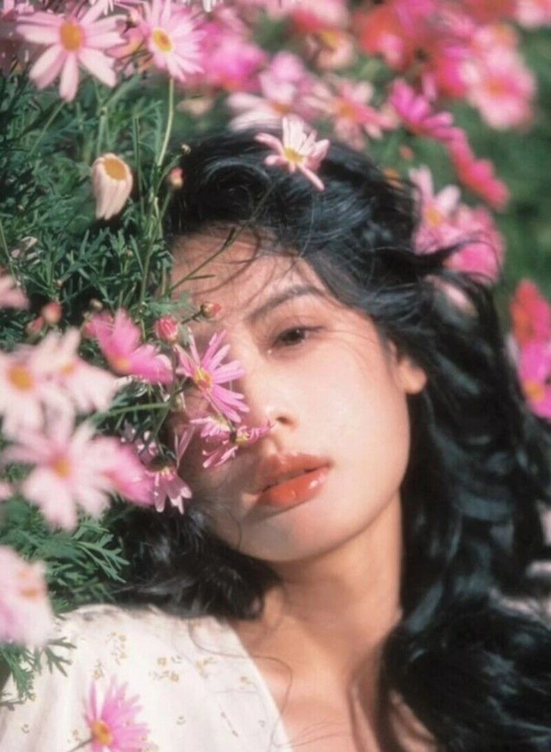 ảnh cô gái cầm hoa che mặt buồn