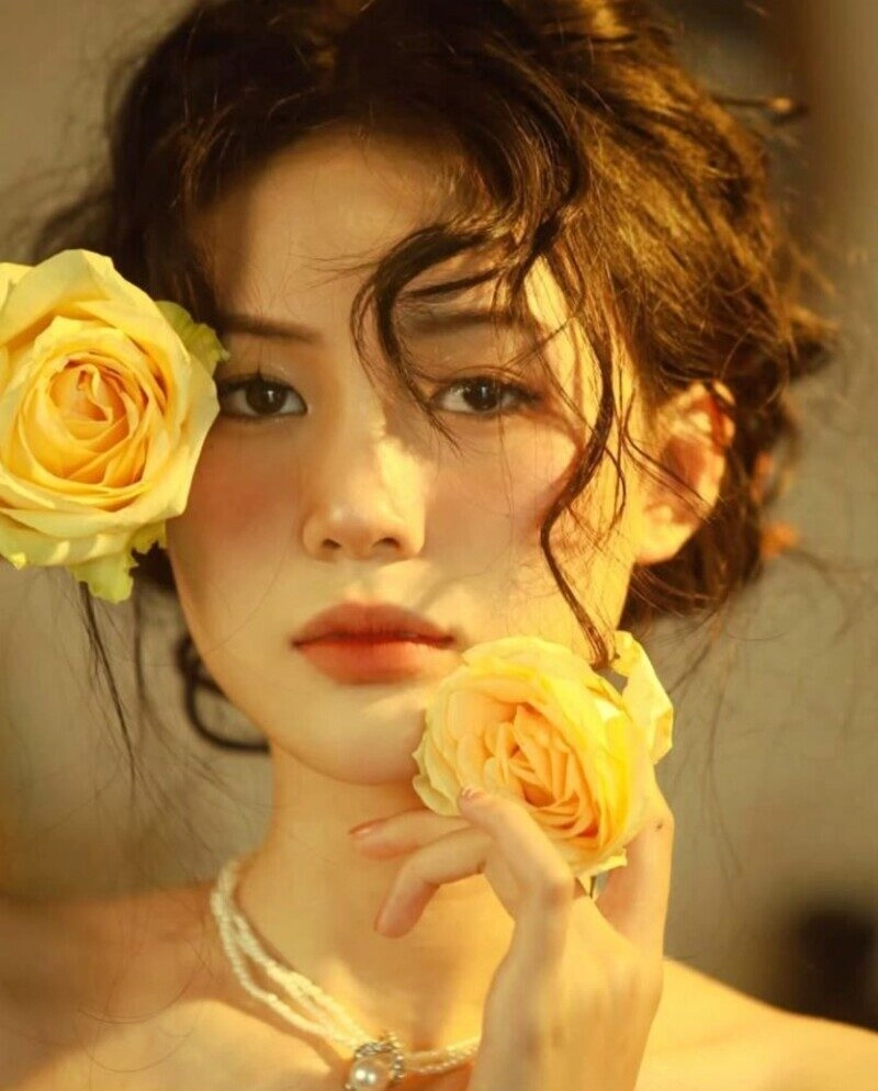 ảnh cô gái cầm hoa che mặt buồn