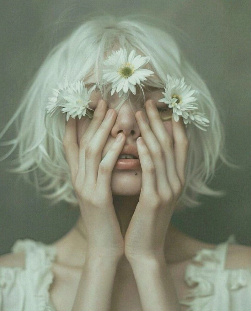 ảnh cô gái cầm hoa che mặt buồn