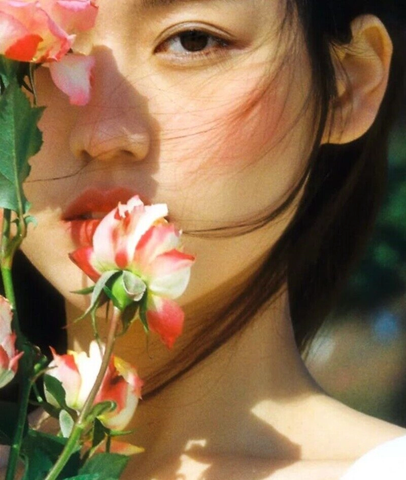 ảnh cô gái cầm hoa che mặt buồn